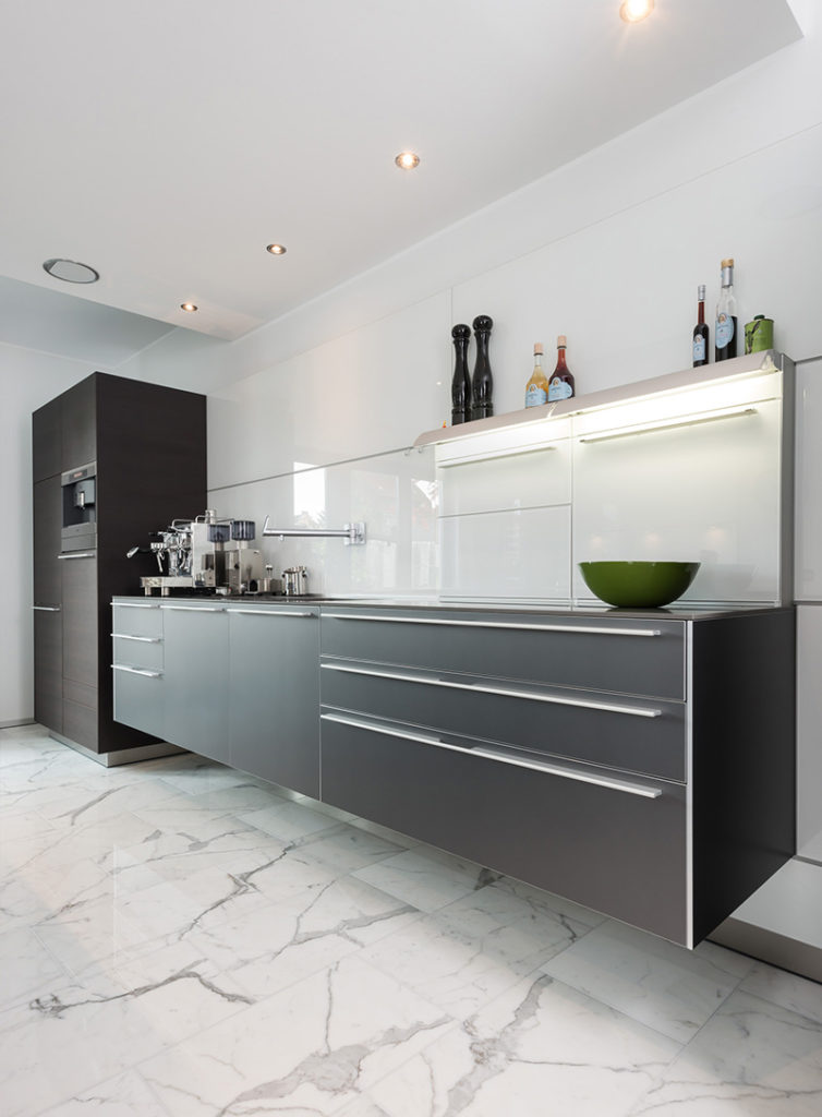 INTACT Küche - Mattschwarze trifft auf hochglänzenden Marmorboden.